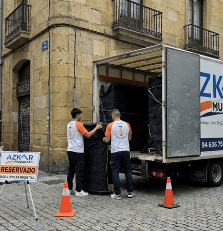 Trabajadores de Azkar Mudanzas cargando cajas en una furgoneta, mostrando una tarifa por m3 mudanza bilbao eficiente.