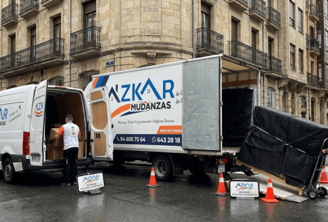 Furgoneta vs camion mudanza bilbao: dos vehículos de mudanza, uno pequeño y otro grande, con cajas y operarios de mudanzas cargando y descargando.