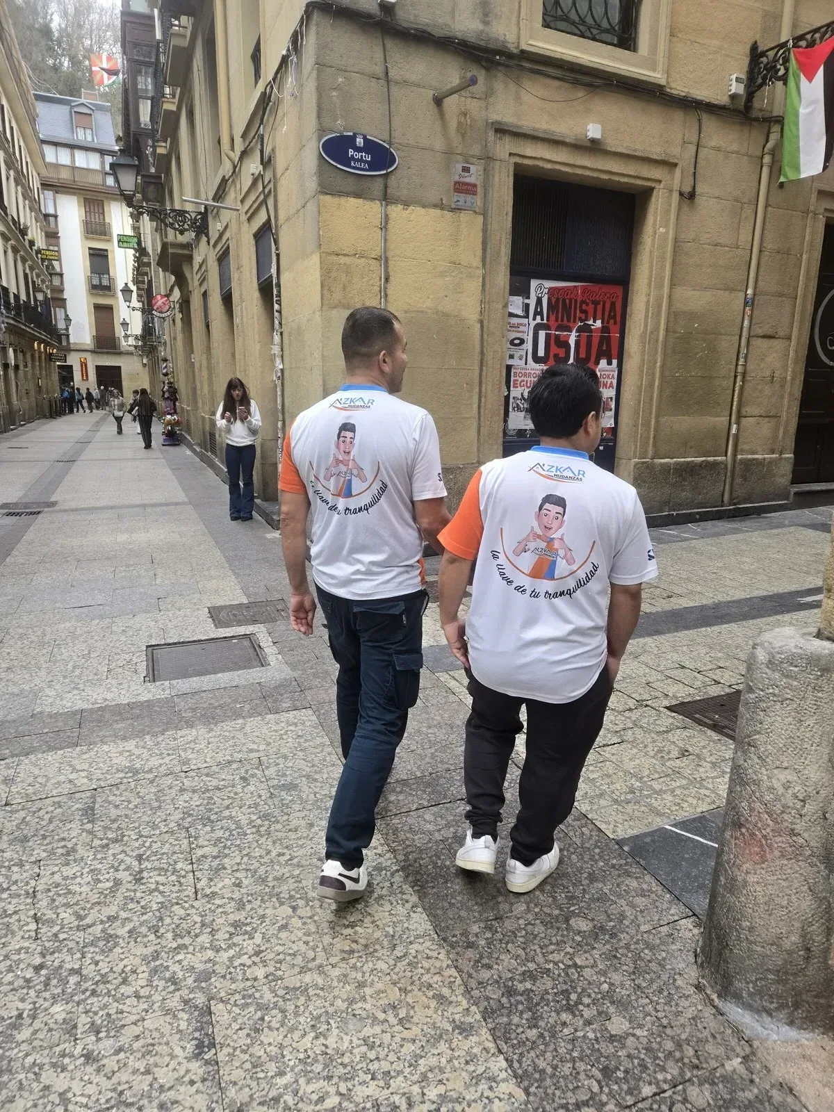 Dos trabajadores de Azkar Mudanzas caminando por Portu Kalea en el Casco Viejo de Bilbao durante un servicio de mudanza urgente
